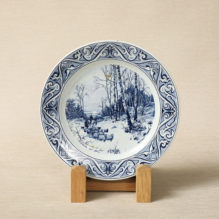 A Petrus Regout delft blue collector's plate featuring a seasonal landscape c. 1890