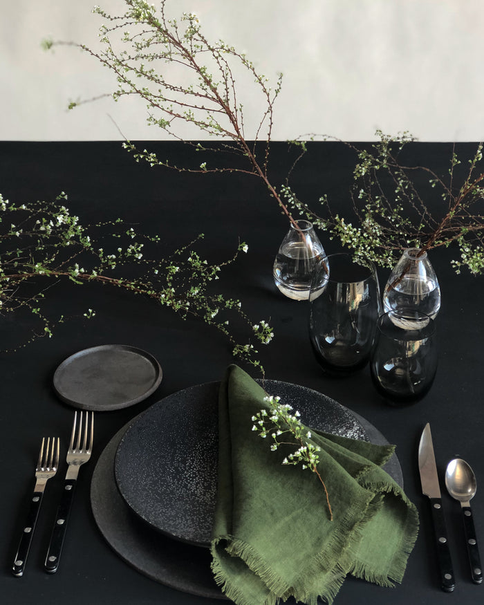 sabre stainless steel flatware set with black resin handles in placesetting