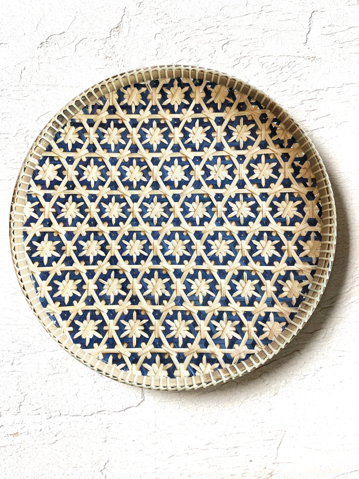 light tan woven tray with navy blue mosaic star pattern 12 inches on white table