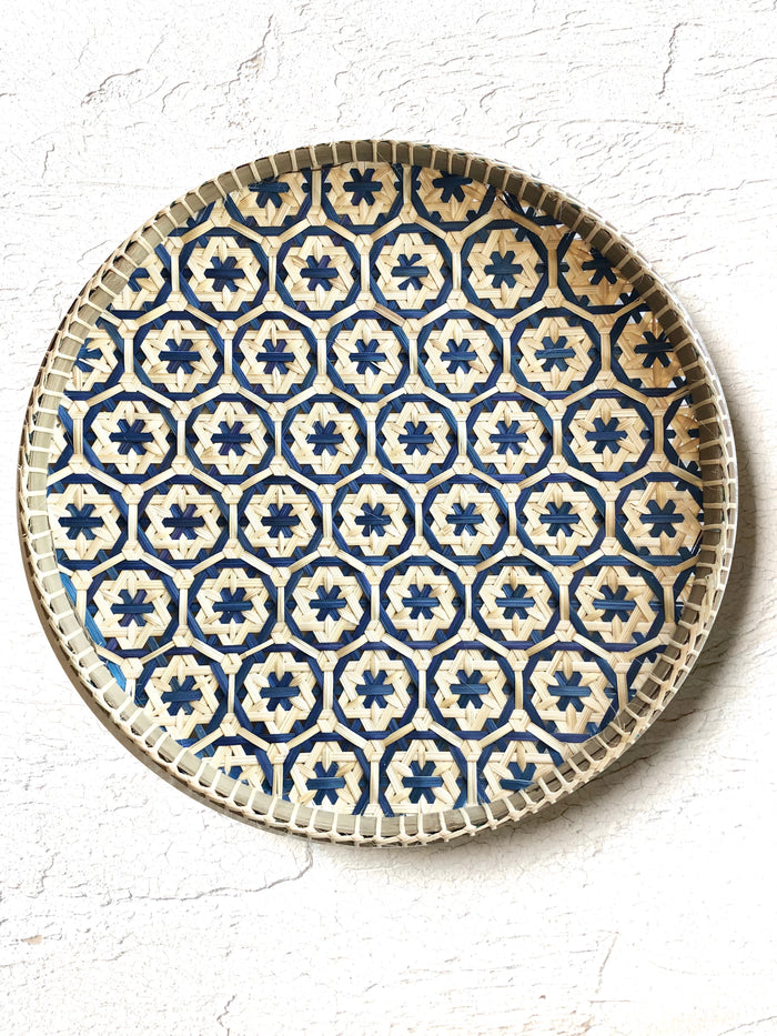 light tan woven tray with navy blue mosaic flower pattern 12 inches on white table